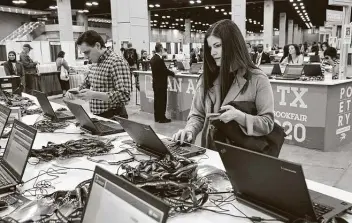  ?? Tom Reel / Staff photograph­er ?? Elizabeth Clark from Pittsburgh signs in at the Associatio­n of Writers & Writing Programs at the Convention Center. This year 23 convention­s were canceled, contributi­ng to a $97 million impact on the city.
From page C1