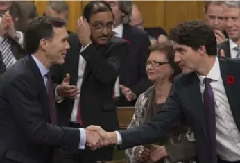  ?? ADRIAN WYLD/THE CANADIAN PRESS ?? Finance Minister Bill Morneau shakes hands with Prime Minister Justin Trudeau after Tuesday’s economic update.