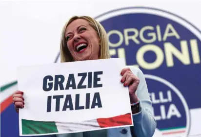  ?? (Guglielmo Mangiapane/Reuters) ?? LEADER OF Brothers of Italy Giorgia Meloni holds a ‘Thanks, Italy’ sign on Monday at the party’s election night headquarte­rs in Rome.