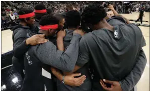  ?? More photos at arkansason­line.com/127bryant/.
(AP/Eric Gay) ?? Toronto Raptors players huddle following a moment of silence for Kobe Bryant before Sunday’s game against the San Antonio Spurs in San Antonio.