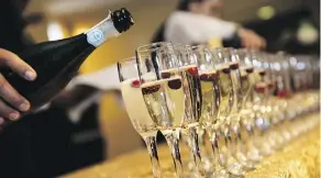  ??  ?? Drinks are poured on Nov. 30 during the Festival of Trees luncheon gala at the Shaw Conference Centre.