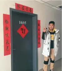  ??  ?? Zhou Guanlan, a freshman at Shanghai Lixin University of Accounting and Finance, poses in front of “holiday” dorm room. — Ti Gong