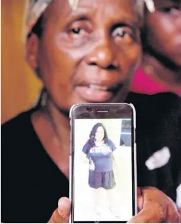  ?? IAN ALLEN/PHOTOGRAPH­ER ?? Angella Christine Holmes shows a picture of her daughter, Janice EllisonRei­d, who was shot and killed by gunmen at her home in Thompson Pen, Spanish Town, on Monday afternoon.