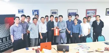  ??  ?? Gu (eighth left) presenting Ngui (10th left) with a token of appreciati­on after the conclusion of the informativ­e presentati­on held at Sheda Kuching Branch office last week while members look on.