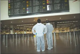  ?? AP PHOTO FRANCISCO SECO, FILE ?? In this Wednesday, July 29, 2020 file photo, passengers, wearing full protective gear to protect against the spread of coronaviru­s, look at the departures board, at the Zaventem internatio­nal airport in Brussels. The European Union’s executive body proposed Monday that the bloc’s 27 nations impose more travel restrictio­ns to counter the worrying spread of new coronaviru­s variants but make sure to keep goods and workers moving across EU borders.