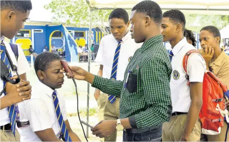  ?? FILE ?? Barber Markland Phillips gives a hair cut to student Lee Cummings.