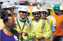  ??  ?? Constructi­on workers line up to eat Thursday during a barbecue at the Raiders stadium site.