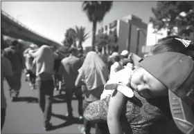  ?? Rebecca Blackwell/AP ?? Sleeping: A sleeping Honduran girl is carried as a group of Central American migrants, representi­ng the thousands participat­ing in a caravan trying to reach the U.S. border, undertake an hours-long march to the office of the United Nations' humans rights body in Mexico City, Thursday. Members of the caravan which has stopped in Mexico City demanded buses Thursday to take them to the U.S. border, saying it tis too cold and dangerous to continue walking and hitchhikin­g.