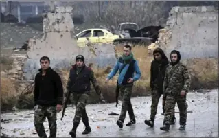  ?? SANA VIA AP ?? Photo from Syrian news agency shows troops and gunmen marching through the streets of east Aleppo Tuesday.