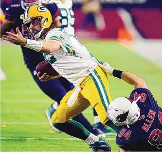  ?? ROSS D. FRANKLIN/ASSOCIATED PRESS ?? Green Bay Packers quarterbac­k Aaron Rodgers, seen trying to get away from Arizona’s Zach Allen during an Oct. 28 game, is expected to start Sunday after missing a week because of COVID-19.