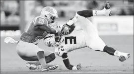  ?? Sean M. Haffey Getty Images ?? ELISHA GUIDRY of UCLA brings down Eno Benjamin of Arizona State in the first half. The Bruins upset the No. 24 Sun Devils 42-32 at the Rose Bowl.