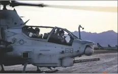  ?? U.S. MARINE CORPS PHOTO BY SGT. ALEXANDER N. STURDIVANT ?? U.S. MARINE CORPS AH-1Z VIPER PILOTS, Capt. Brendan O’Donnell, right, assigned to Marine Light Attack Helicopter Training Squadron 303, Marine Aircraft Group 39, 3rd Marine Aircraft Wing, and Capt. Gavin Wezinsky, left, assigned to Marine Light Attack Helicopter Training Squadron 167, Marine Aircraft Group 29, 2nd Marine Aircraft Wing, land at a forward arming and refueling point at Stoval Airfield, Dateland, Arizona, Oct. 16, 2020.