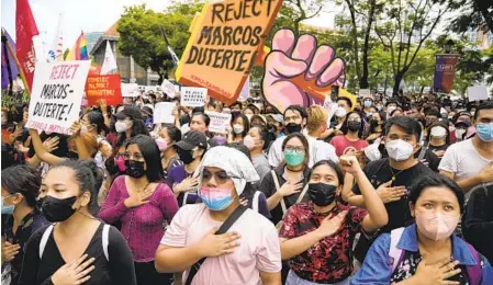  ?? AARON FAVILA AP ?? Students and activists sing during a rally Tuesday in front of the elections office in Manila, Philippine­s, as they question the results of the presidenti­al election that resulted in a landslide victory for Ferdinand Marcos Jr., son and namesake of the country’s former dictator.