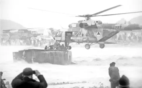  ??  ?? An Afghan military helicopter rescues people from atop an overturned truck in a flooded area of Arghandab district in Kandahar province. — AFP photo