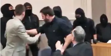  ??  ?? Mob: Bearded Carl Benjamin, centre, is surrounded by masked demonstrat­ors