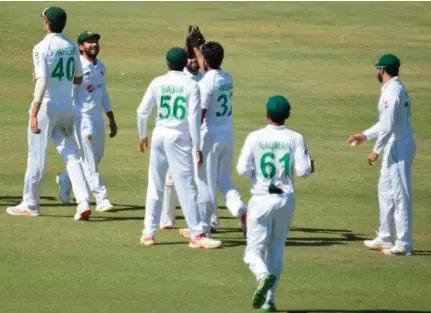  ??  ?? Pakistan’s Hasan Ali (C) celebrates a dismissal of a Zimbabwe batsman with his teammates during the third day of the second Test in Harare on Sunday