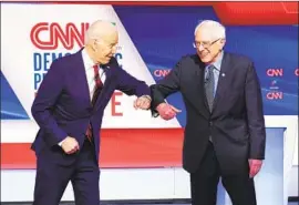  ?? Evan Vucci Associated Press ?? JOE BIDEN, now the presumptiv­e Democratic nominee, and Sen. Bernie Sanders bump elbows before the presidenti­al primary debate in March in Washington.