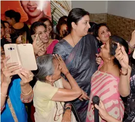  ?? — PTI ?? Women take selfies with Union textiles minister Smriti Irani during an election campaign at Varanasi on Wednesday.
