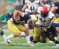  ?? Darron Cummings / Associated Press ?? Notre Dame quarterbac­k Drew Pyne, left, is sacked by Cincinnati’s Malik Vann (42) on Saturday.