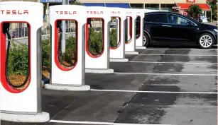  ?? (Arnd Wiegmann/Reuters) ?? AN ELECTRIC-POWERED Tesla car stands at a charging station in Melide, Switzerlan­d.