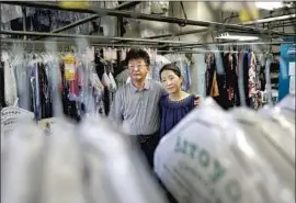  ?? Christina House Los Angeles Times ?? YOON Dong Kim, left, and his wife, Stacy Kim, own Arroyo Cleaners in Pasadena. They would rather their two sons fulfill their dreams than help with the business.