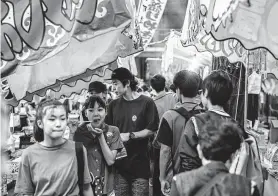  ?? Irwin Wong / For The Washington Post ?? The family area of Awa Odori street festival features toys for sale and a performanc­e for kids in Tokyo.