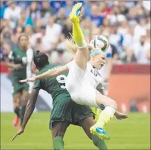  ?? Jonathan Hayward
Canadian Press/Associated Press ?? JULIE JOHNSTON (19) of the U.S. leaves terra firma as she vies with Nigeria’s Desire Oparanozie for control of the ball.