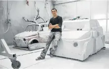  ?? Picture: AFP ?? CONSUMERIS­M CRITIQUE: Nazareno Biondo sits on his ongoing sculpture made from Carrara marble representi­ng the iconic Fiat 500