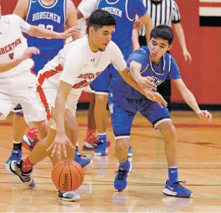  ?? LUIS SÁNCHEZ SATURNO/THE NEW MEXICAN ?? Robertson’s Derek Montaño fends off St. Michael’s defender Ruben Salazar on Friday in Michael Marr Gymnasium in Las Vegas, N.M. On defense, he helped stymie the Horsemen’s attack and led the Cardinals to a dominating 59-45 district win.
