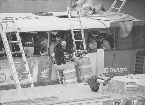  ?? WAYNE CUDDINGTON / POSTMEDIA NEWS ?? First responders attend to victims of a horrific rush-hour bus crash at the Westboro Station near Tunney’s Pasture.