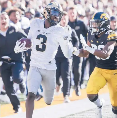  ?? MATTHEW HOLST/GETTY ?? Purdue wide receiver David Bell (3) runs in front of Iowa defensive back Kaevon Merriweath­er on Saturday.