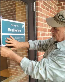  ?? EVAN TUCHINSKY — ENTERPRISE-RECORD ?? Chico State professor Mark Stemen puts up a flier at Colusa Hall on Thursday, promoting the symposium This Way to Resilience in Chico this week.