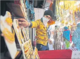  ?? AP ?? ■
A shopkeeper displays jewellery for sale at a market in Jammu earlier this month after small shops and other businesses were reopened in several states.