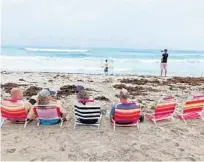  ?? JOE CAVARETTA/SOUTH FLORIDA SUN SENTINEL ?? Spectators watch surfers in Delray Beach on Sunday.