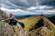  ?? JONATHAN TENNANT/ALAMY ?? A hiker scrambles up Striding Edge, located in Britain’s Lake District.