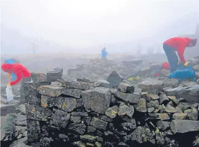  ??  ?? Volunteers hard at work clearing up a plethora of rubbish left by walkers on Ben Nevis.