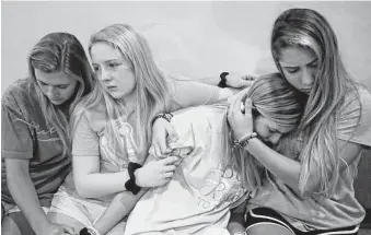  ?? Melissa Phillip photos / Staff photograph­er ?? A group of girls comforts one another during the weekly student church service Wednesday at Woodlands Church campus in Atascocita. The service focused on the fatal accidents.