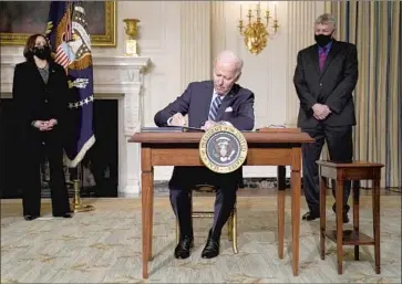  ?? PRESIDENT BIDEN Evan Vucci Associated Press ?? signs executive actions Wednesday in the White House dealing with climate change. “We’ve already waited too long to deal with this climate crisis,” Biden said. “We can’t wait any longer.”