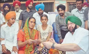  ?? SAMEER SEHGAL/HT ?? Chief minister Capt Amarinder Singh with the family of martyr Paramjit Singh at Vein Poin village in Tarn Taran on Sunday.