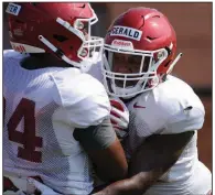  ?? (NWA Democrat-Gazette/Andy Shupe) ?? Arkansas senior Dorian Gerald (right) is in the running to be one of the Razorbacks’ starters at defensive end this season. He missed all of last season after suffering a bruised artery in his neck in the season opener against Portland State.
