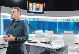  ?? PAUL CHIASSON THE CANADIAN PRESS ?? Moderator Patrice Roy checks out the set for Thursday night’s Quebec election leaders debate in Montreal, on Wednesday. Quebec’s provincial election is October 1.