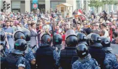  ?? AFP ?? Lebanese protesters try to break through security barriers in front of the cabinet office in central Beirut’s Martyr Square on Sunday. —