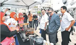  ??  ?? Menteri Kemajuan Luar Bandar dan Wilayah Dato’ Sri Ismail Sabri Yaakob tertarik dengan demonstras­i masakan pada Majlis Pra-Pelancaran KUD 2017.