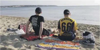  ?? Foto: dpa ?? Deutsche Urlauber entspannen an einem Strand von Mallorca.