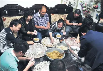  ?? ZHANG YIFEI / FOR CHINA DAILY ?? Wang Kuan and his wife Wang Shurong make Zhengzhou, Henan province. with their own children, adopted children and grandchild­ren at their home in