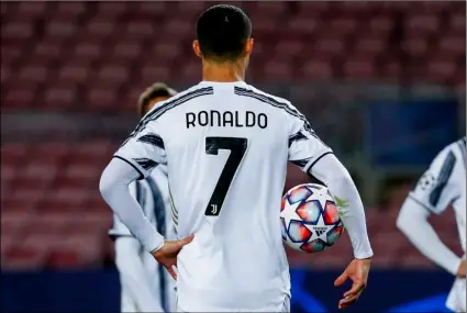  ?? AP Photo/Joan Monfort ?? Juventus’ Cristiano Ronaldo holds a ball before socoring a penalty kick during the Champions League group G soccer match between FC Barcelona and Juventus at the Camp Nou stadium in Barcelona, Spain, on Dec. 8, 2020.