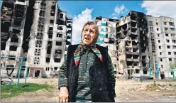  ?? REUTERS ?? A woman reacts as she stands in front of a building, destroyed by the shelling, amid the Russian invasion of Ukraine, in Borodianka, Kyiv region, on Monday.