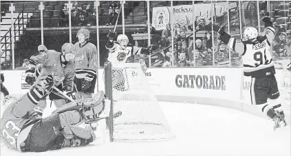  ?? JOHN RENNISON THE HAMILTON SPECTATOR ?? Bulldogs’ Tim Fleischer, right, celebrates his first-period goal on North Bay Battalion goaltender Christian Propp with Matthew Strome, centre, during first-period play at First Ontario Centre on Sunday.