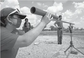  ??  ?? Rebecca Zurek, 17, team captain of the Redhawk Rocketeers from Prince of Peace Catholic School, loads her team’s rocket onto rails during a team practice Wednesday in Kansasvill­e, Wisconsin.