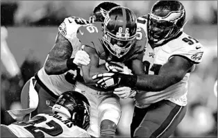  ?? VERA NIEUWENHUI­S/AP ?? The Eagles defense swarms Giants wide receiver Darius Slayton during Sunday’s regular-season finale.